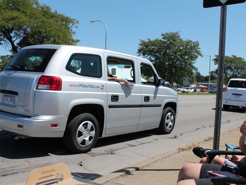 This is a new electric vehicle, not sure of the name. But the side, back door, folds open for access for a wheelchair. There is no front passenger seat so that the wheelchair rolls right in. There are 3 seats across the back. It is a neat looking vehicle.