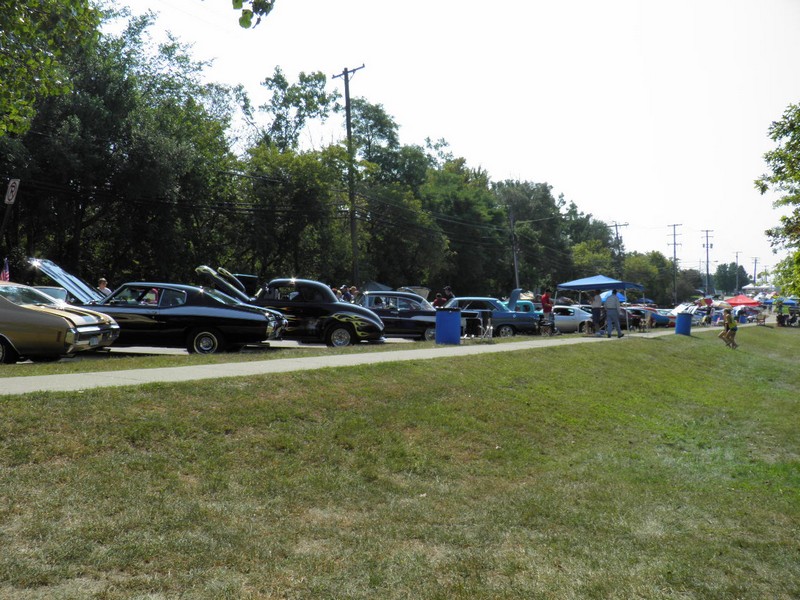 P8290485
The temperature was 90+ degrees. So everyone had to find the shade where they could, we found the shade of the trees in the park, the perfect place to sit. Here is a pic of our view of the cars lining the street.